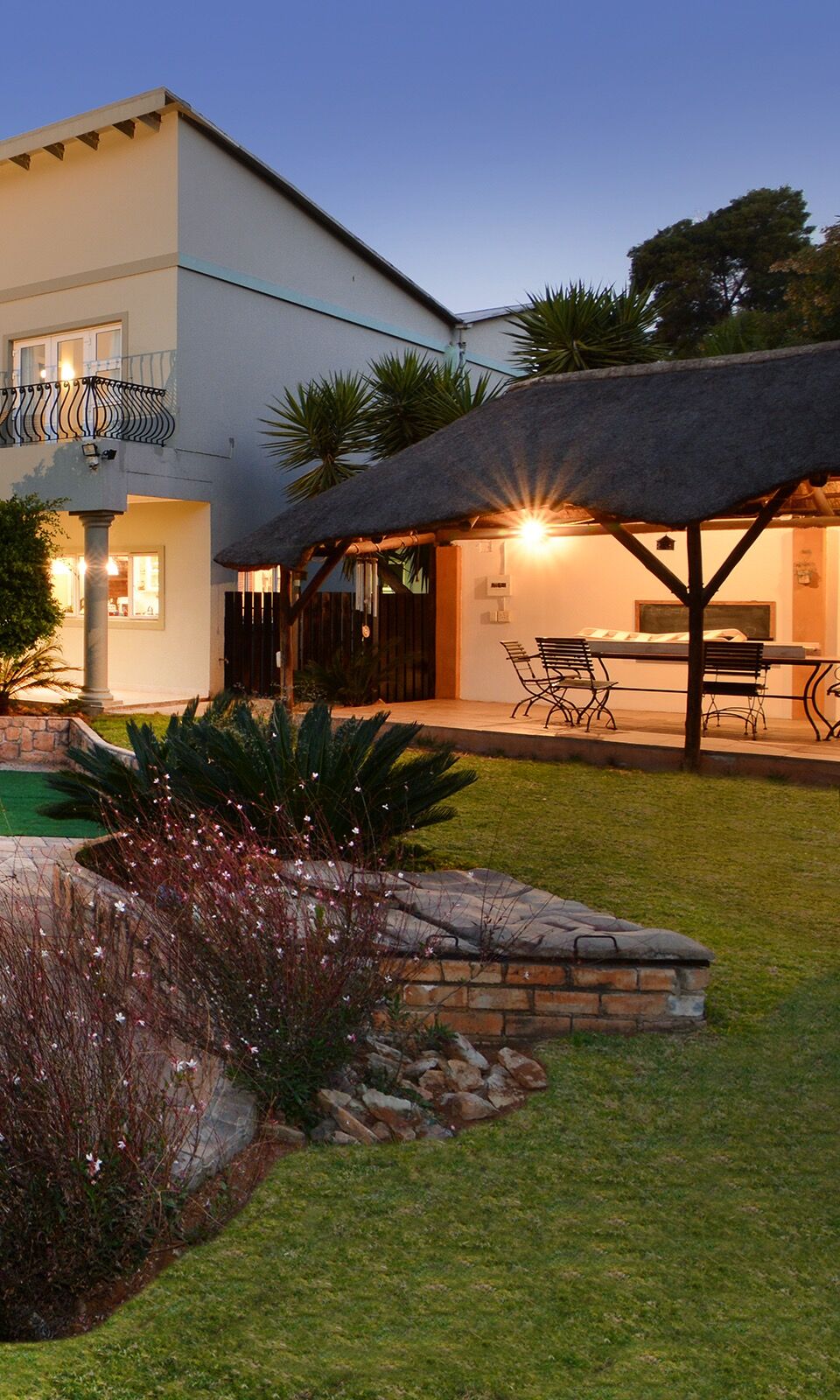 Sandown Guest House lapa with lit dining set at dusk