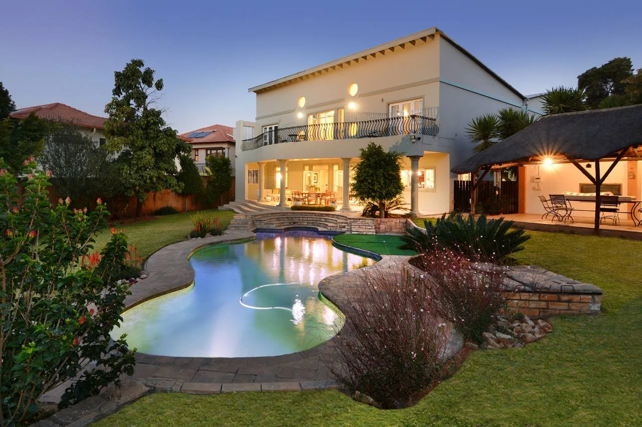 Sandown Guest House at twilight — pool, lapa, and garden lit at dusk, Sandton